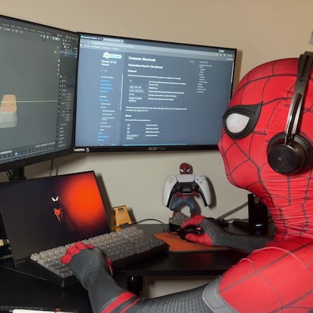 Kyle Truss, founder of WebHead Workshop, designing a web shooter in 3D modeling software while wearing a red and blue superhero suit